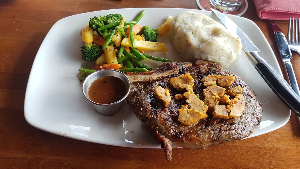 Cowboy Steak with Cajun Butter and Garlic Mashed Potatoes and Seasonal Vegetables