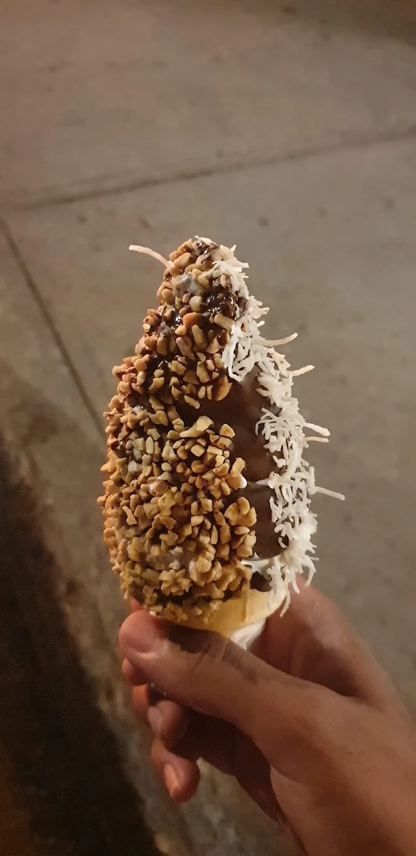 Regular Vanilla Cone Dipped in Espresso Topped with Coconut and Peanuts