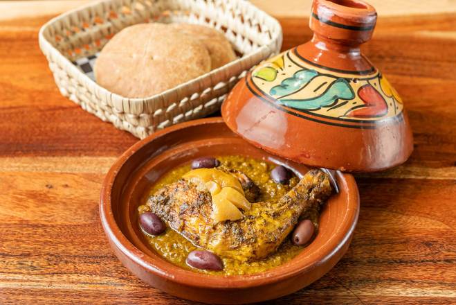 Tajine de poulet aux olives servi avec du pain maison