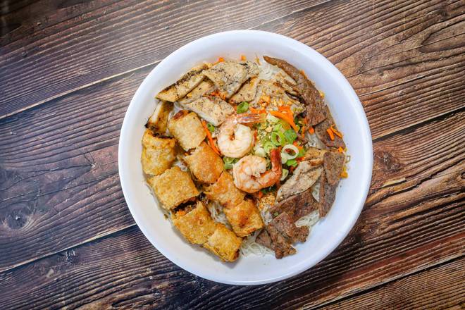 62. Grilled shrimp, chicken, pork, beef, and two spring rolls on vermicelli.