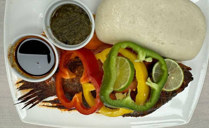 Banku and tilapia with black pepper and green hot chili sauce