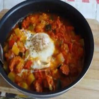 Tajine de saucisse de veau, sauce tomate et œuf, 2 pains ronds à côté / veal sausage tajine, in tomato sauce and eggs