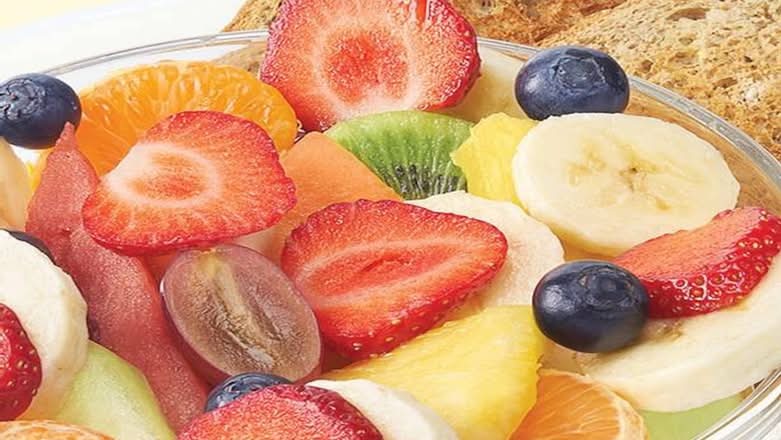 Large bowl of fresh fruit with toast