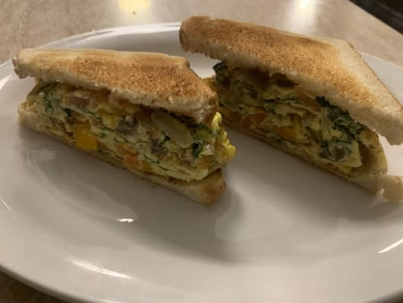 Vegetarian Western Sandwich made with egg, tomato, onion, mushroom and pepper